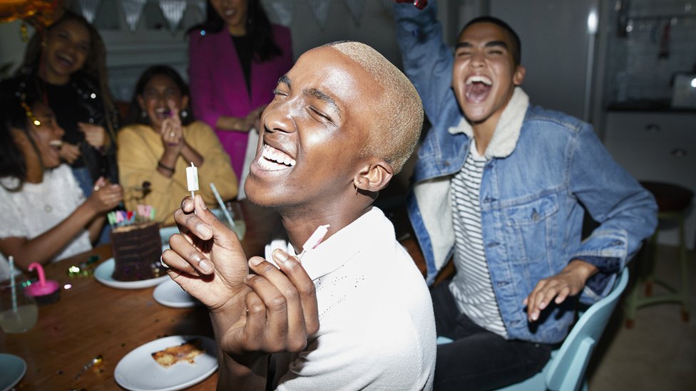 Un grupo de amigos celebra un cumpleaños y ríe.