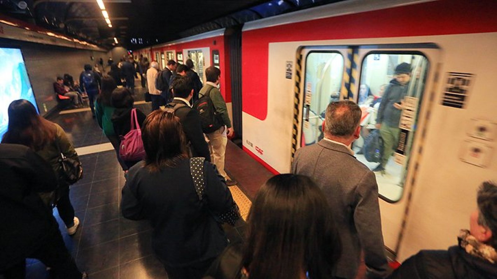 Personas esperando ingresar a vagón de Metro de Santiago