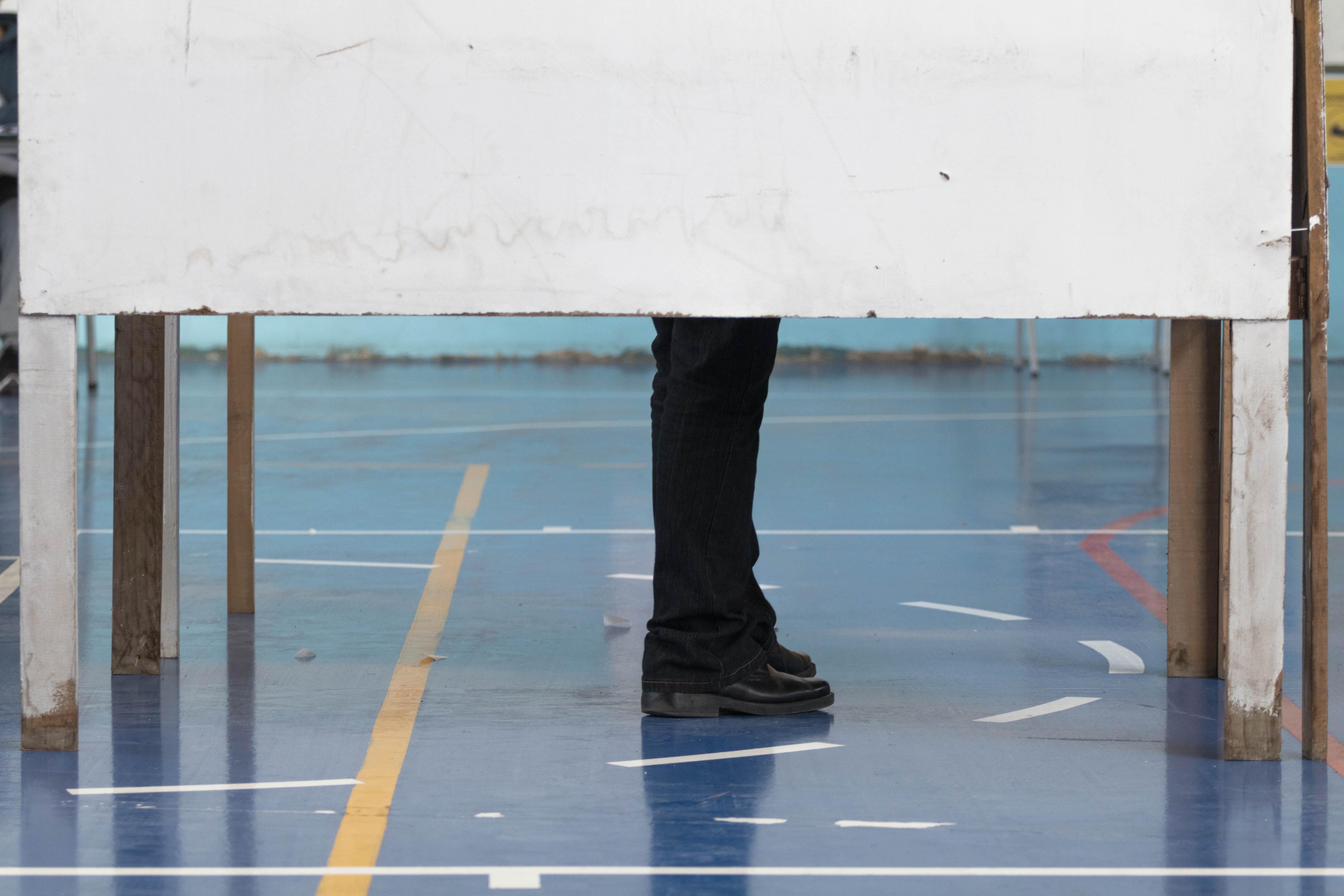 Votante espera por votar dentro de cámara de votación.