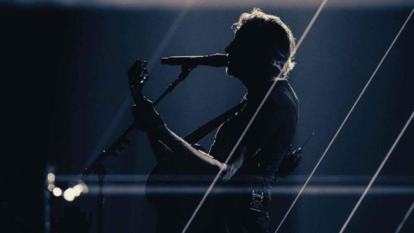 Roger Waters con una guitarra cantando.