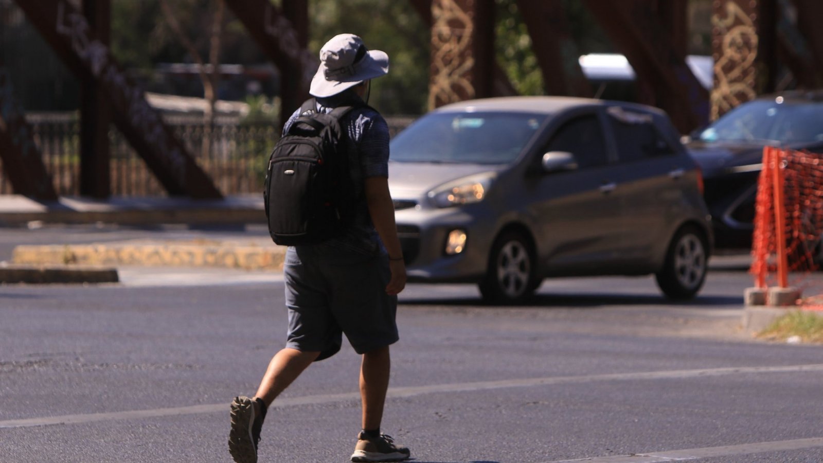 Persona caminando bajo el sol en la calle.