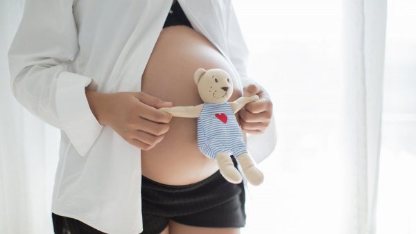 Mujer embarazada con un peluche.