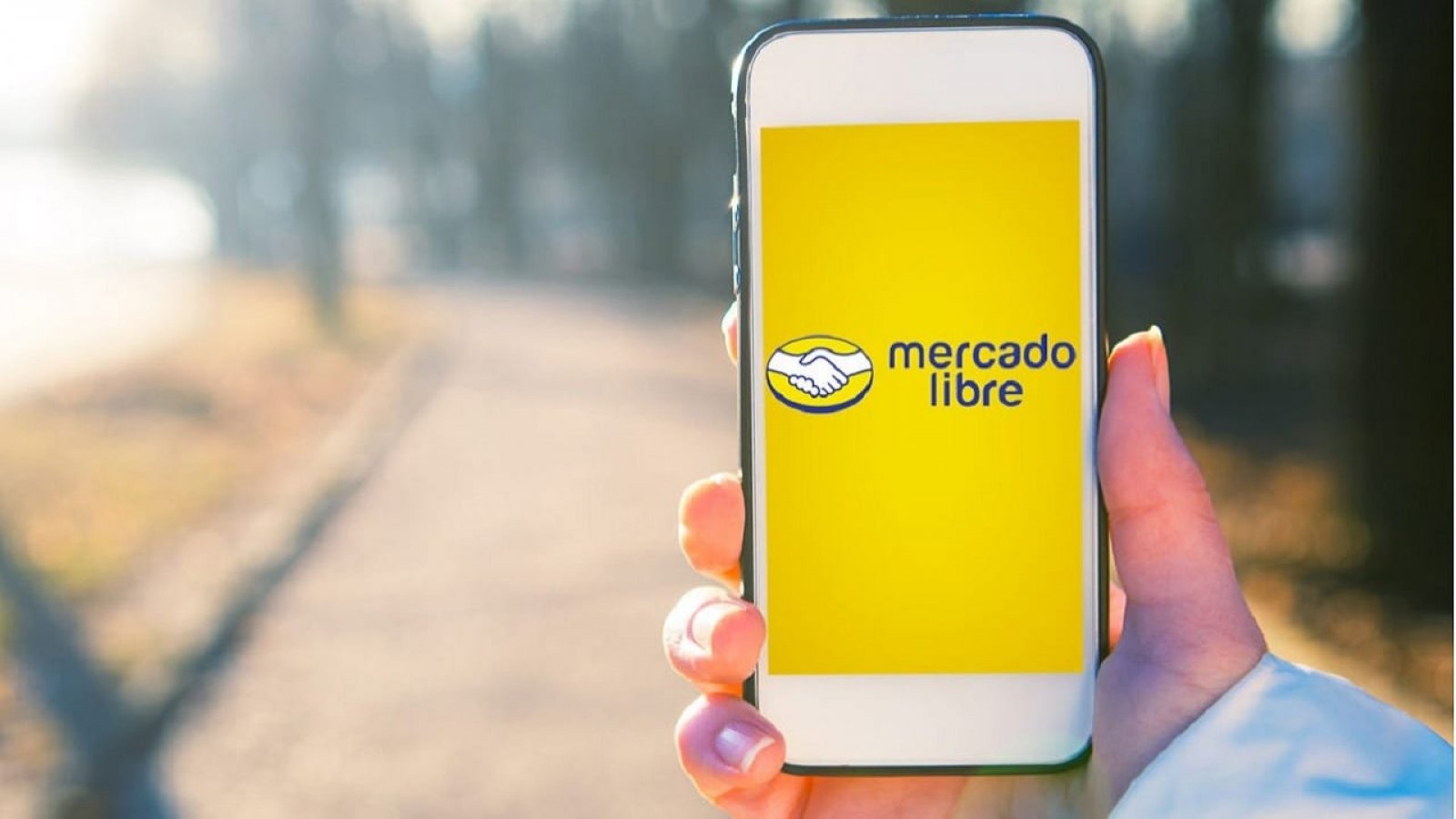 Mano sosteniendo celular con app de Mercado Libre abierta