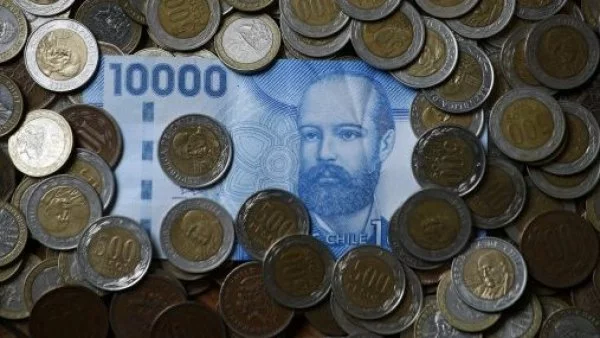 Billete azul de 10 mil en medio de monedas de quinientos pesos.