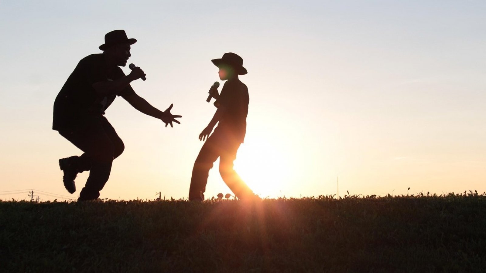 Padre e hijo cantando en el atardecer