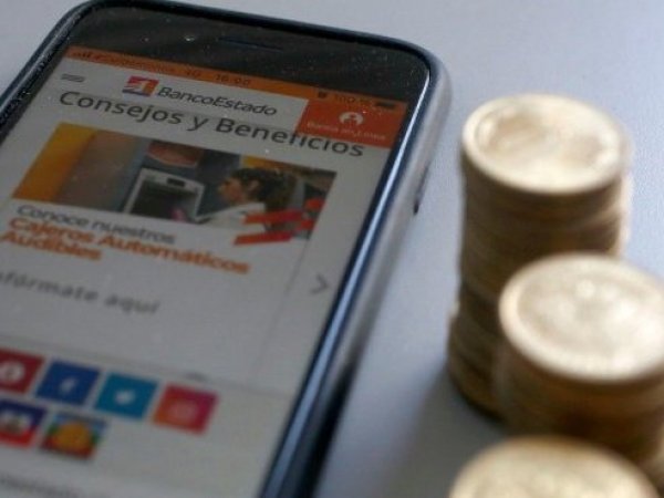 Celular y pantalla con pestaña abierta de la web del BancoEstado. No lo cobraste.