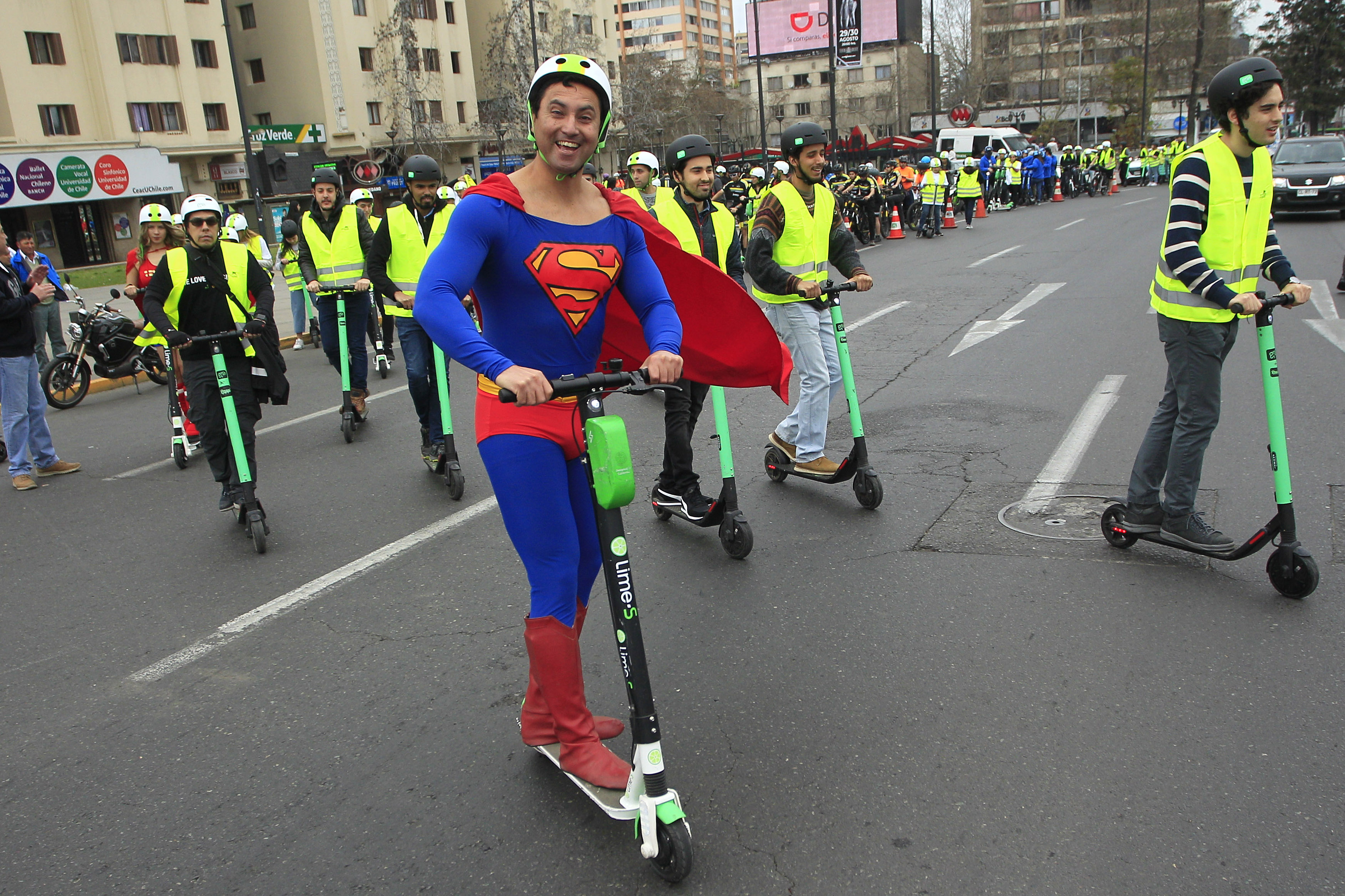 Persona disfrazada de Superman sobre un scooter.