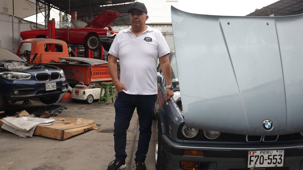 Pacho Kantt, rodeado de autos en su taller de Lima.