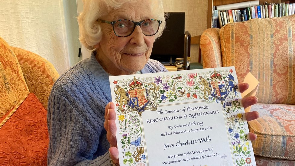 Betty Webb con la invitación a la coronación de Carlos III