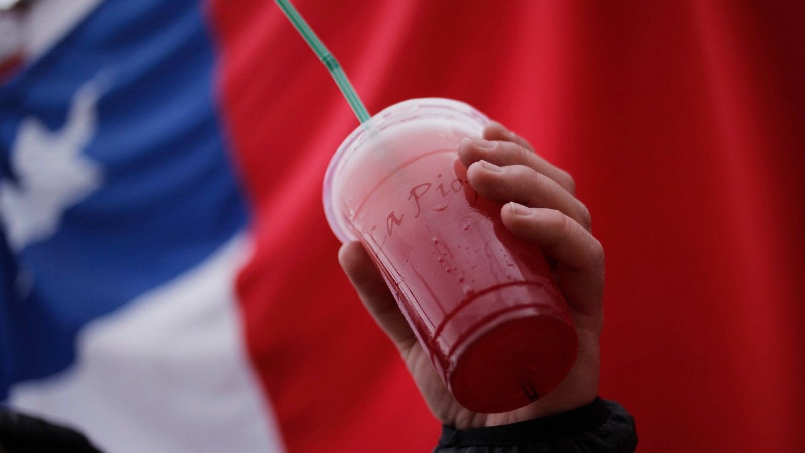 Vaso de terremoto con la bandera chilena atrás.