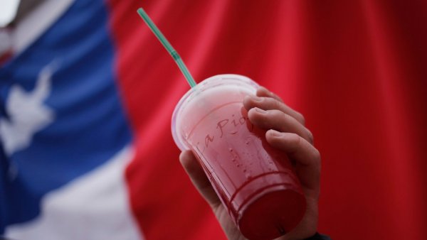 Vaso de terremoto con la bandera chilena atrás.