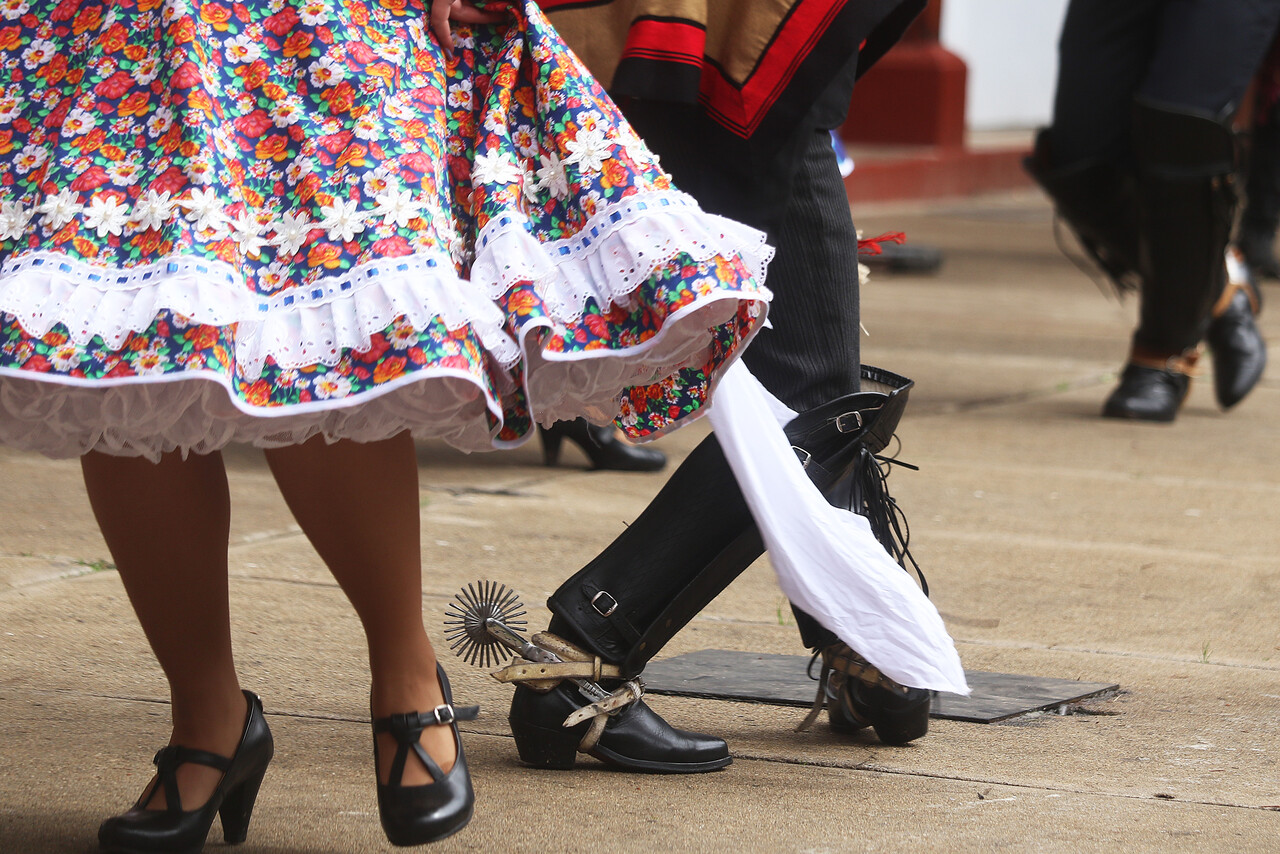 Pies de una muejr y hombre bailando cueca en Fiestas Patrias.