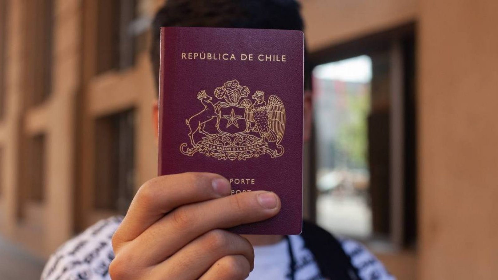 Persona sosteniendo pasaporte de la República de Chile