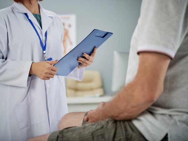 Hombre sentado en el doctor por fimosis.