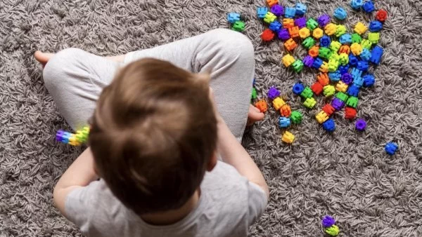 Niño jugando con piezas de colores.
