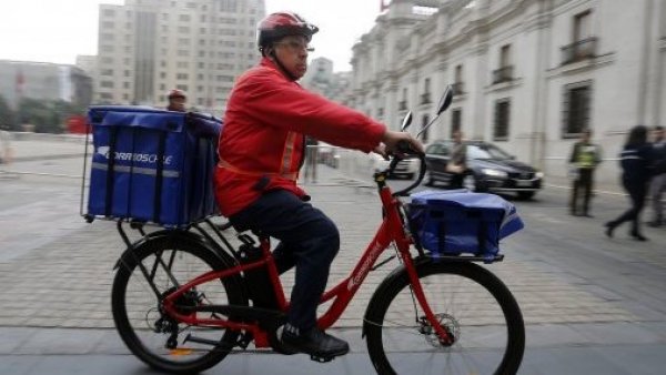 Cartero de Correos de Chile repartiendo paquetes.