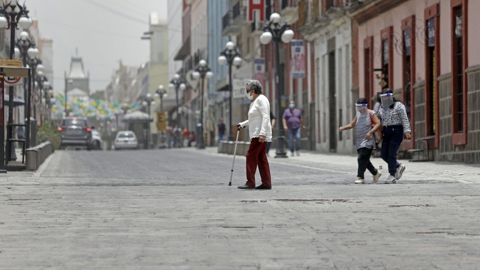 Transeúntes con mascarilla en una calle de Puebla.