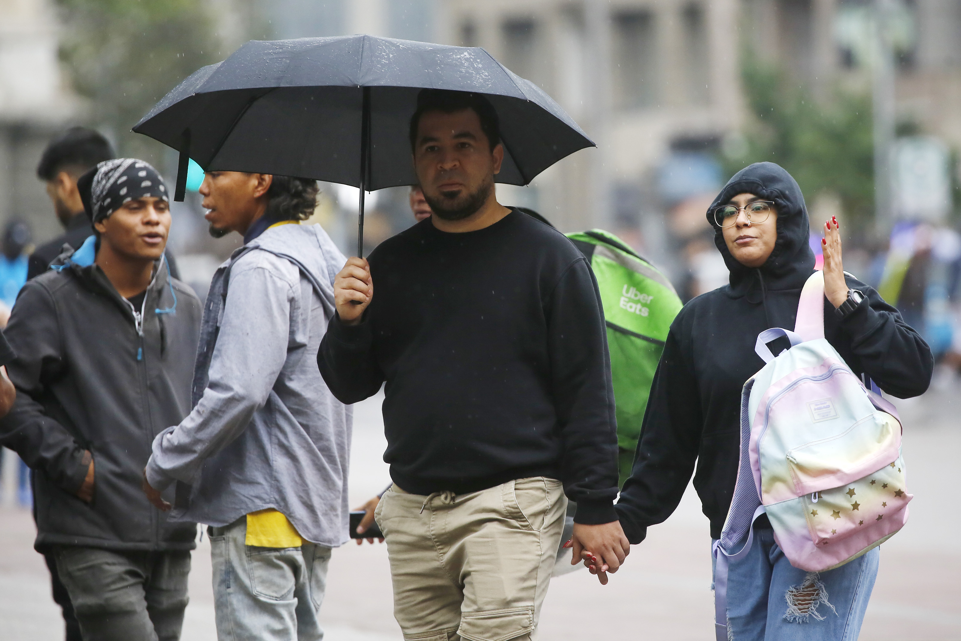 Personas caminando con paraguas.
