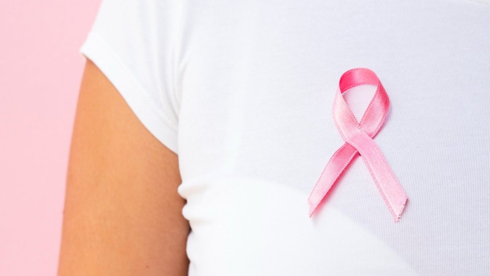 Mujer con un lazo rosado simbolizando la lucha contra el cáncer de mama.