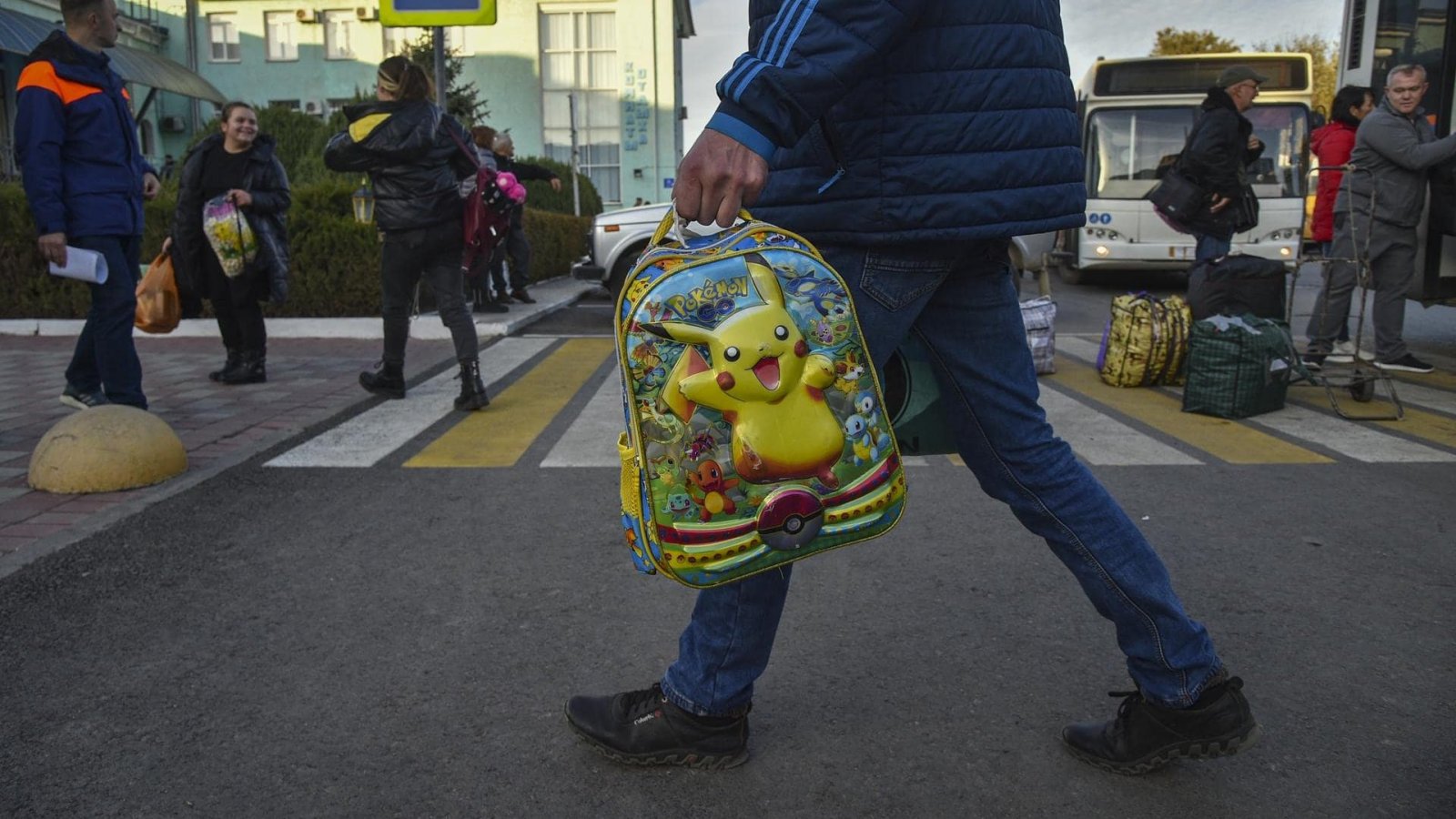 Padre llevando mochila de su hijo por guerra en Ucrania (referencial).
