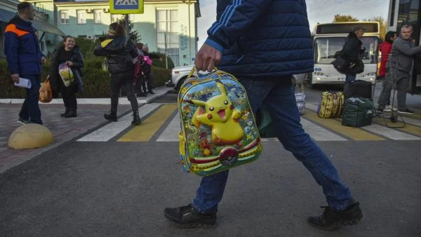 Padre llevando mochila de su hijo por guerra en Ucrania (referencial).