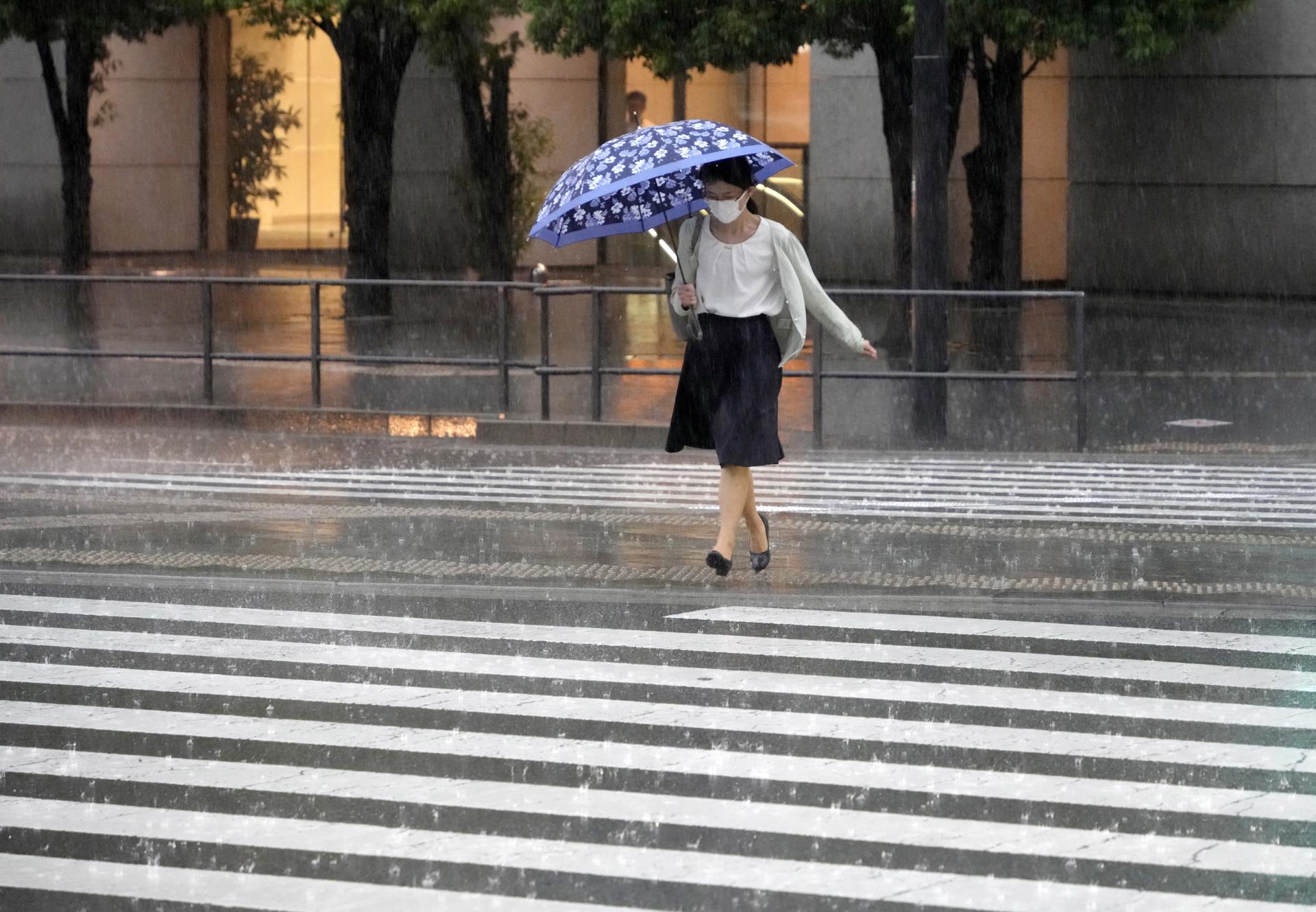Persona caminando bajo la lluvia en Japón