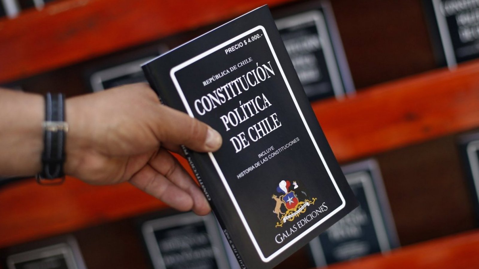 Constitucióno de Chile en la mano de una pesona.