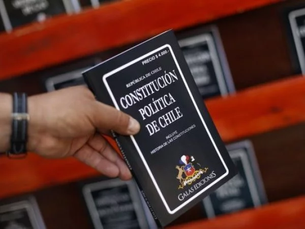 Constitucióno de Chile en la mano de una pesona.