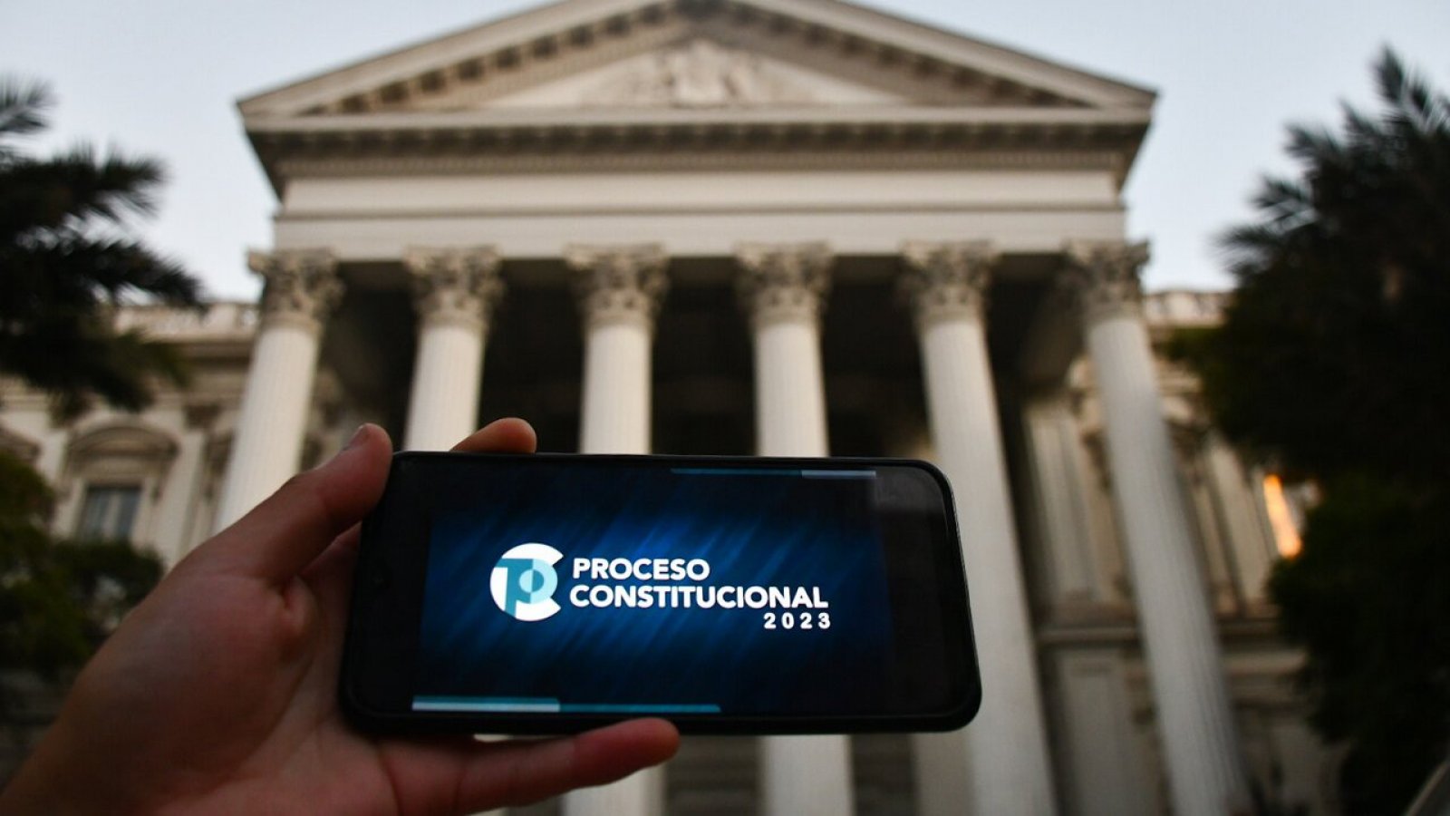 Teléfono con el logo del Proceso Constitucional en el frontis del Congreso Nacional de Santiago,