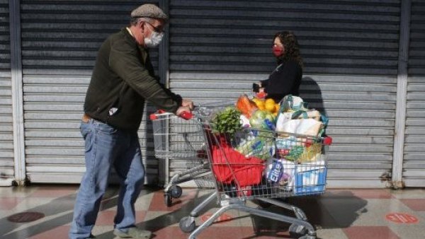 Adultos comprando con carros de supermercado.