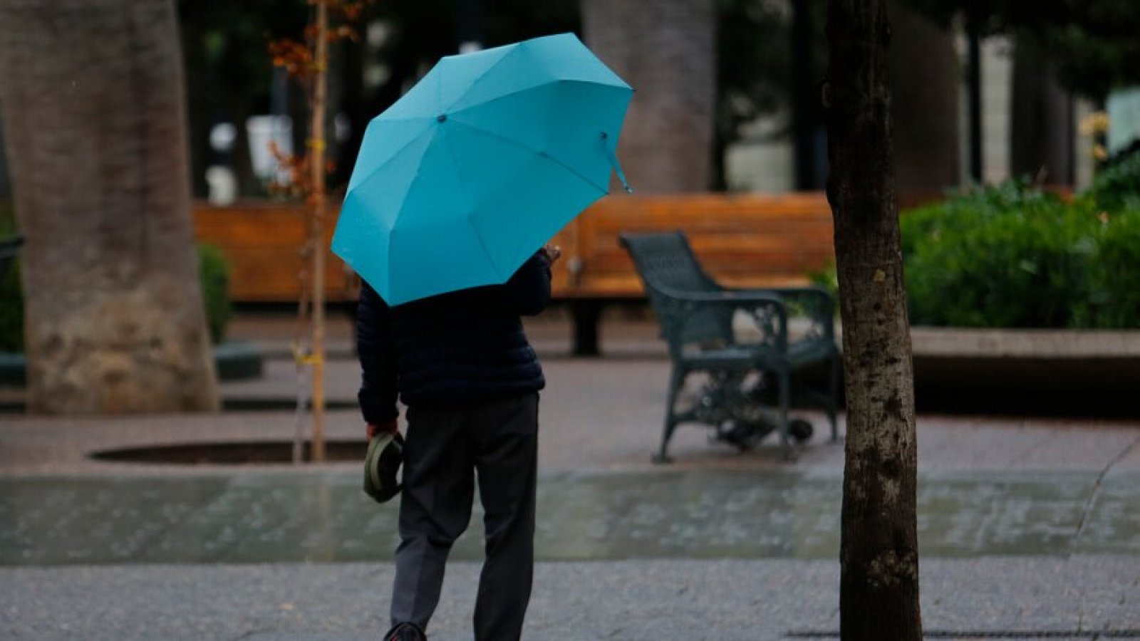 Persona caminando bajo la lluvia en Santiago.