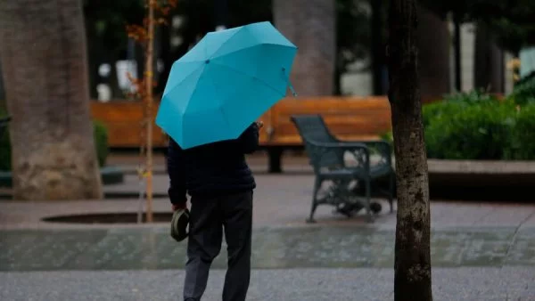 Persona caminando bajo la lluvia en Santiago.