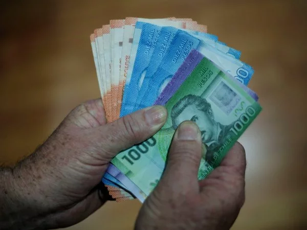 Manos sujetando billetes.