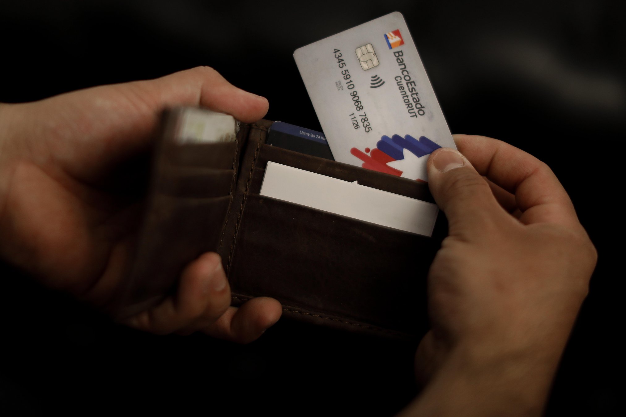Persona sacando la tarjeta CuentaRUT de su billetera.