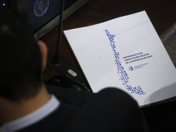 Consejero con un libro del anteproyecto constitucional al lado.