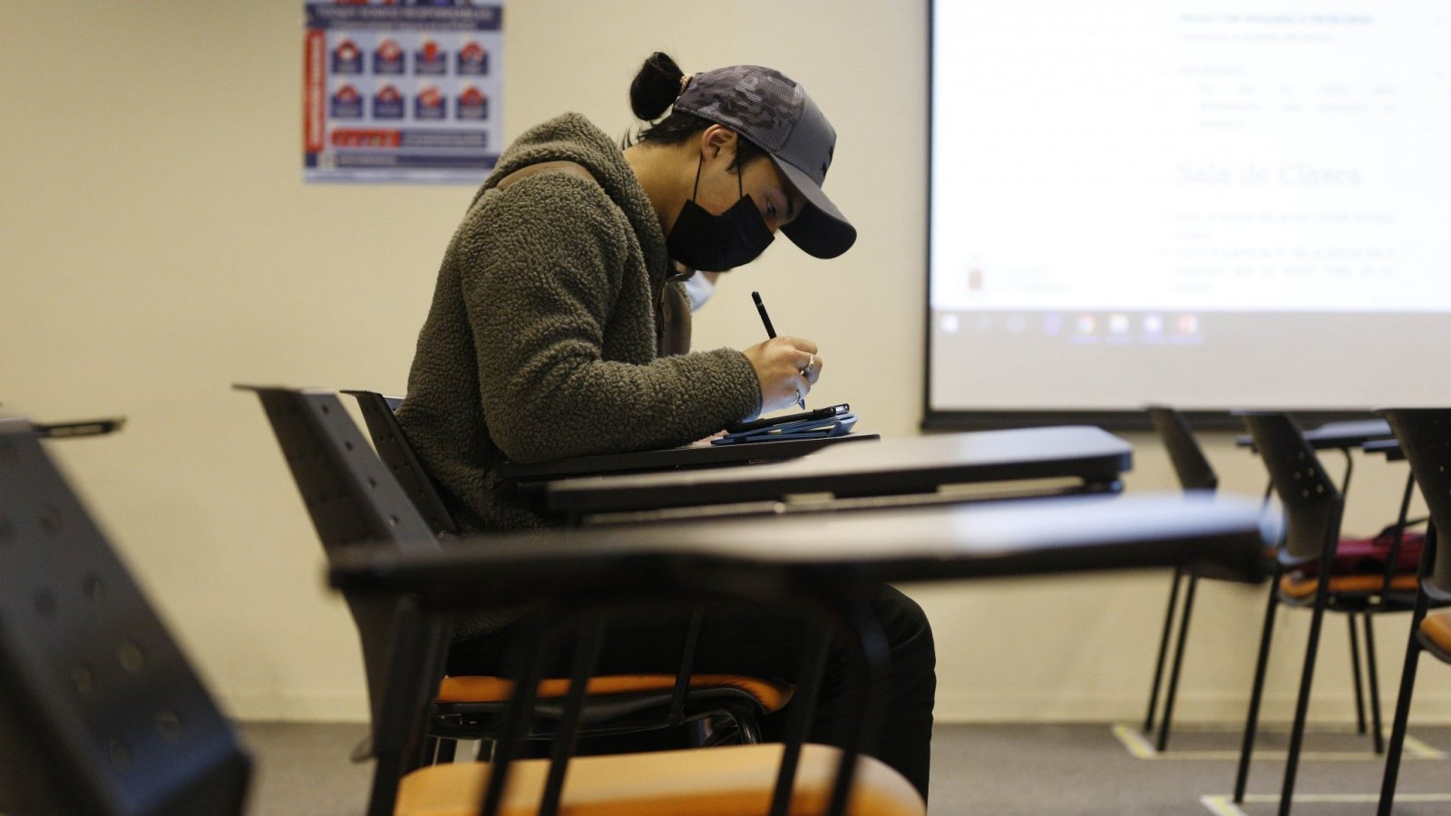 Estudiante de educación superior sentado en un escritorio