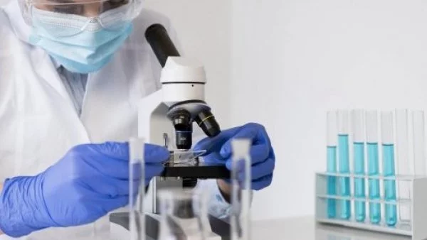 Científico mirando a través de un microscopio.