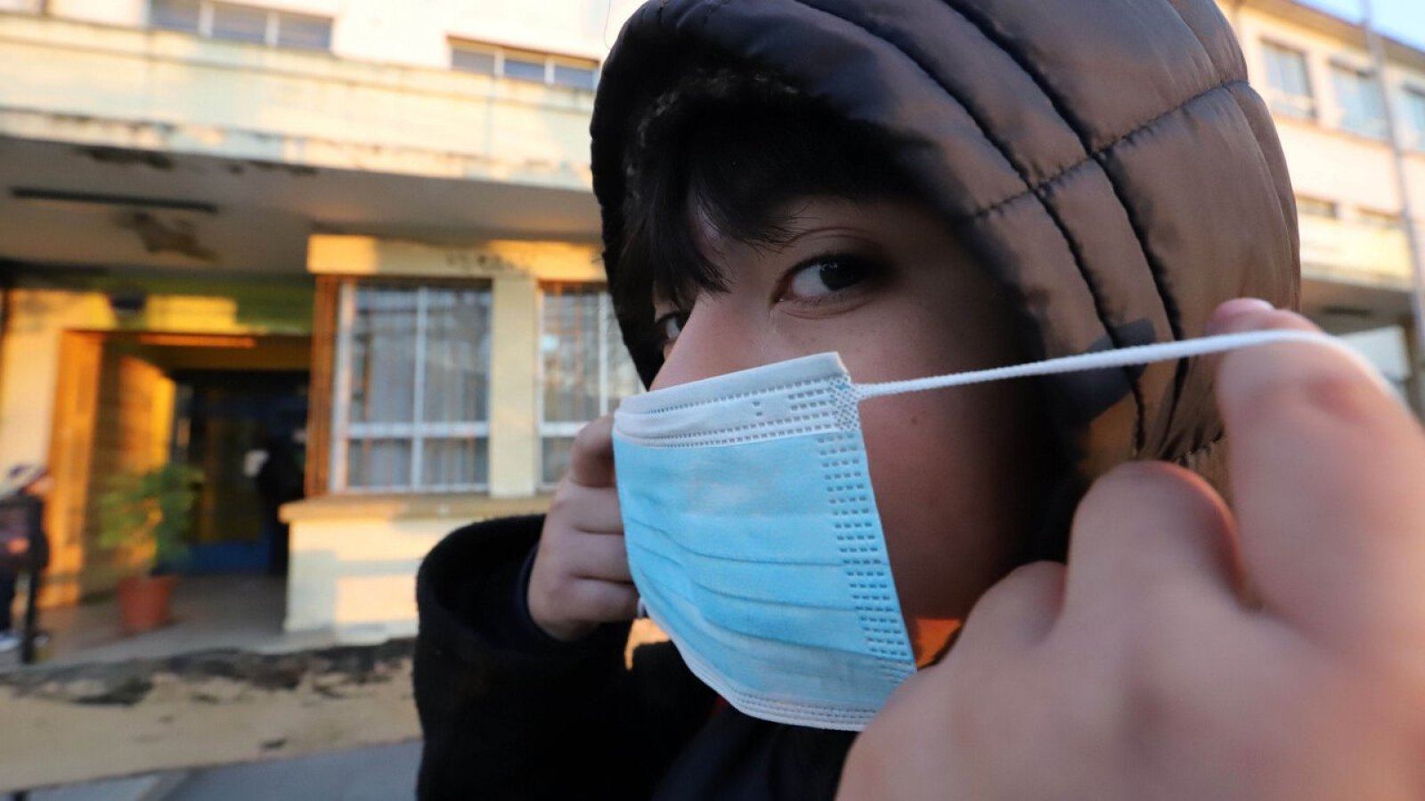 Niño poniéndose una mascarilla