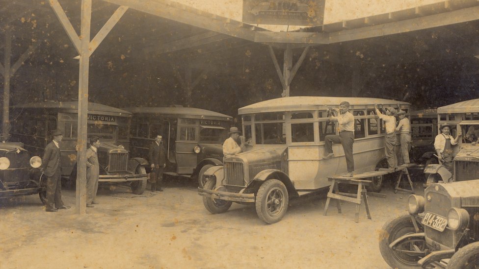 Empleados y vehículos en un taller de carrocería de comienzos del siglo XX.