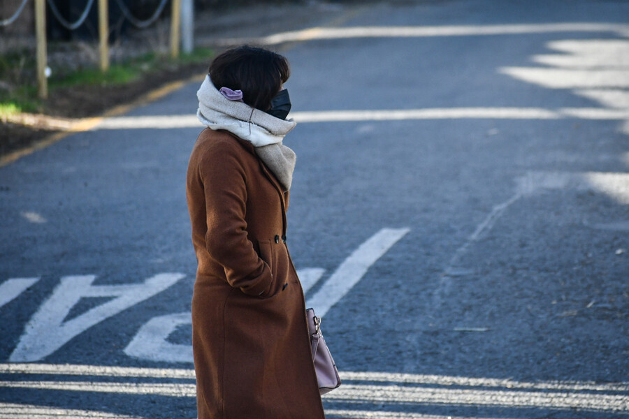 Mujer caminando abrigada por el frío.