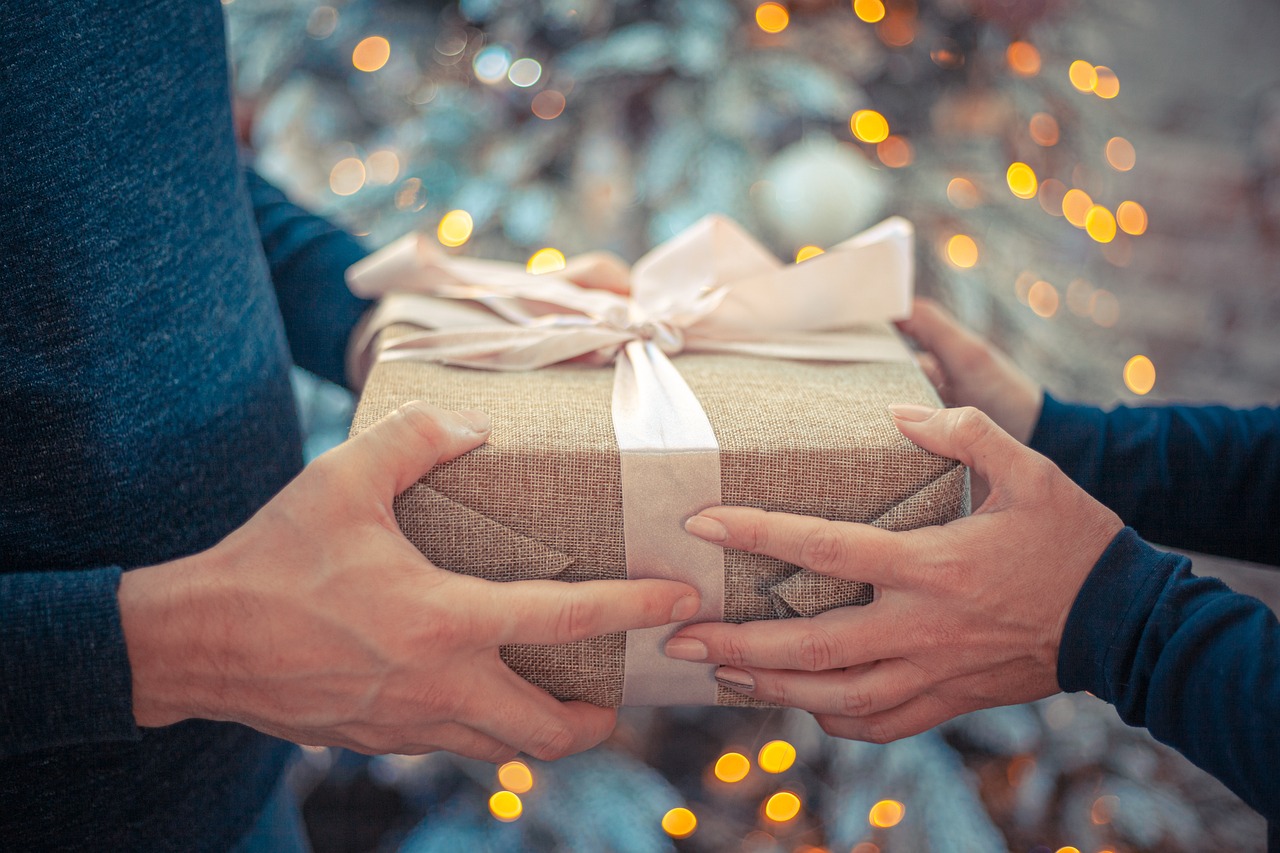 Un hombre y mujer pasándose un regalo.