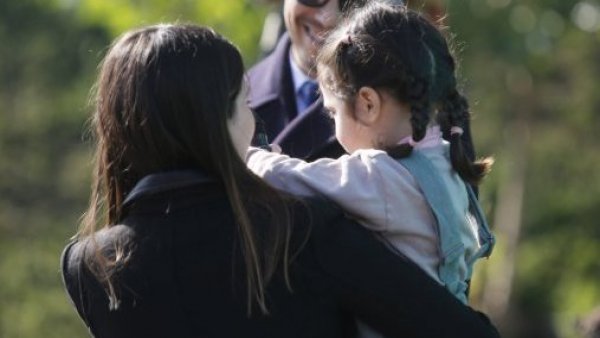 Una mujer con una niña en brazos.