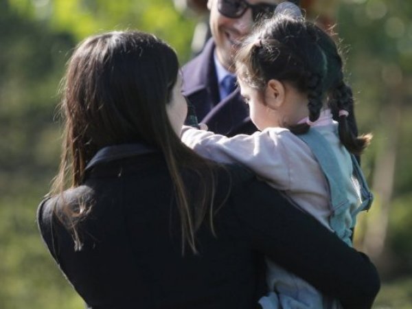 Una mujer con una niña en brazos.