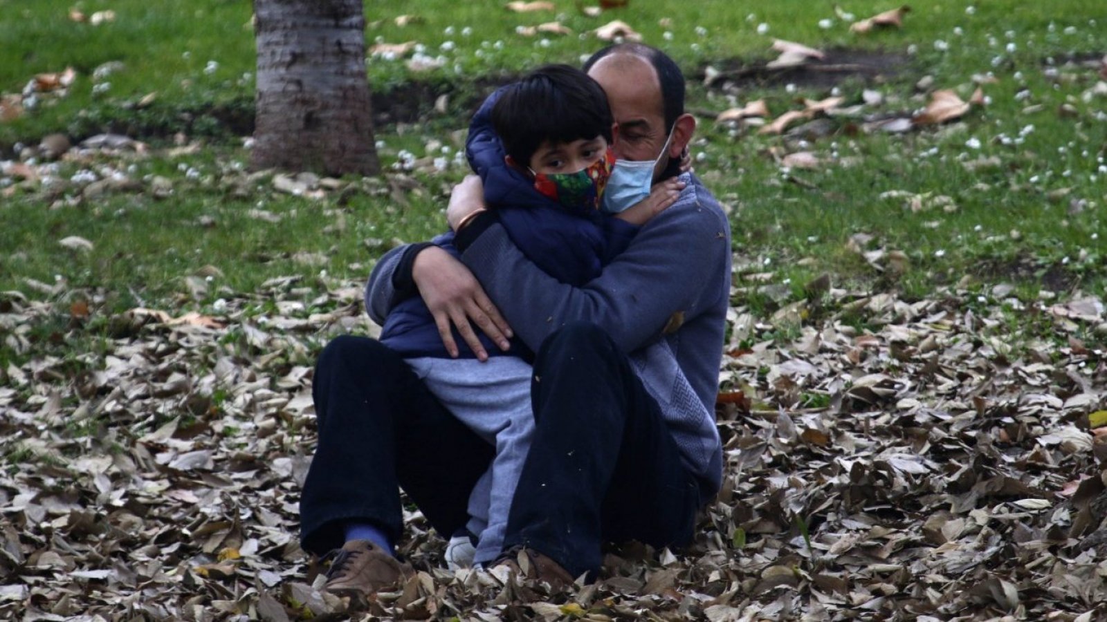 Padre sujetando a su hijo en brazos.
