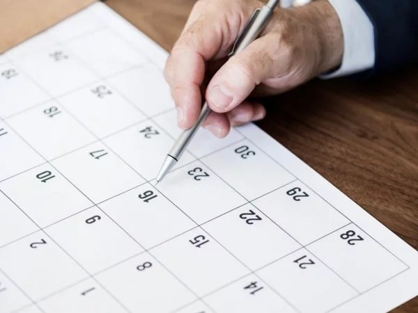 Mano de una persona revisando el calendario.