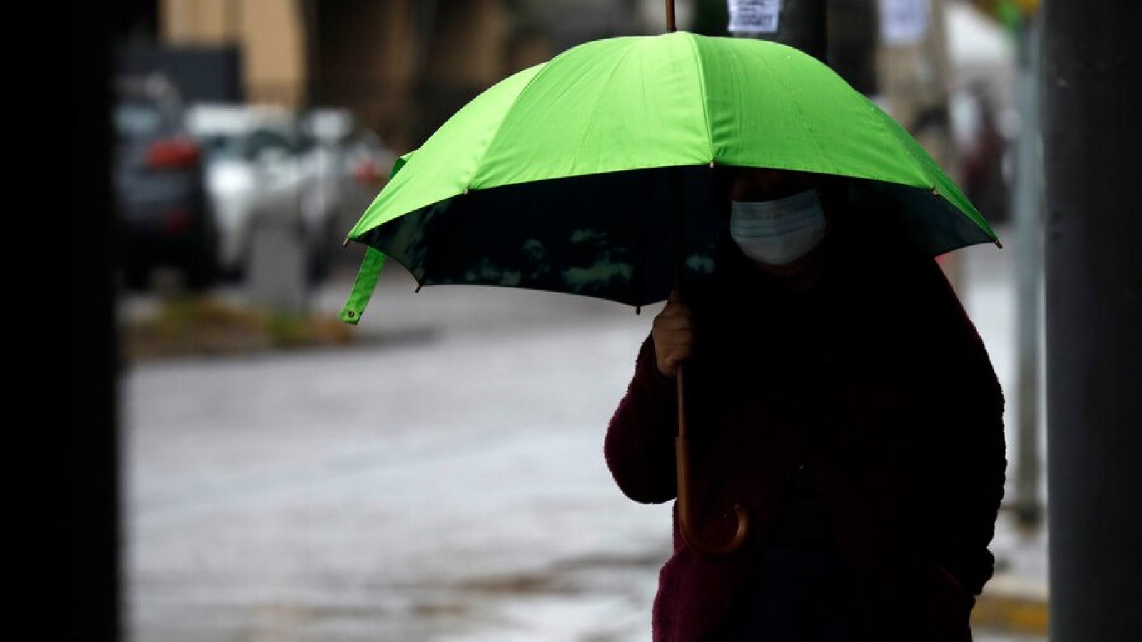 Persona con un paraguas caminando bajo la lluvia.