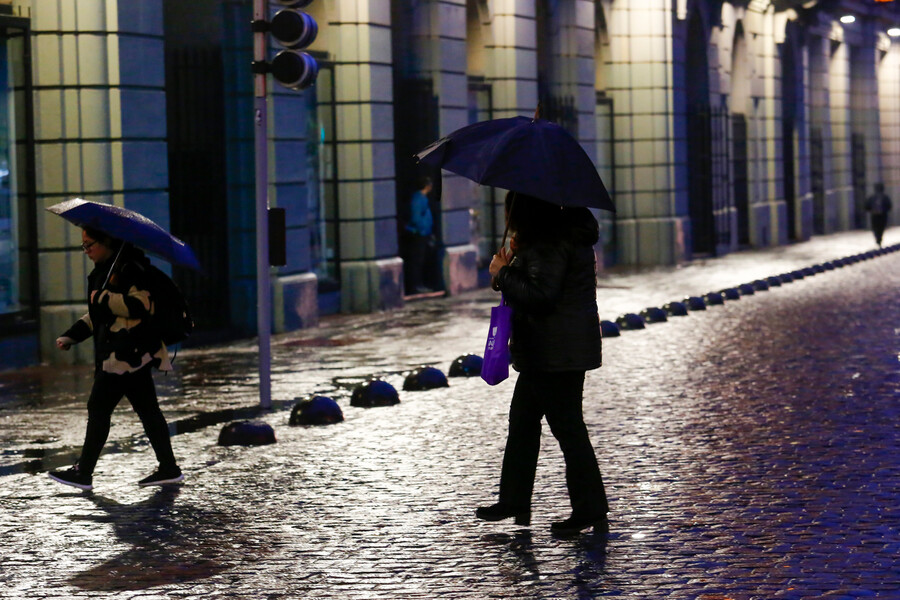 Personas caminando bajo la lluvia en Santiago