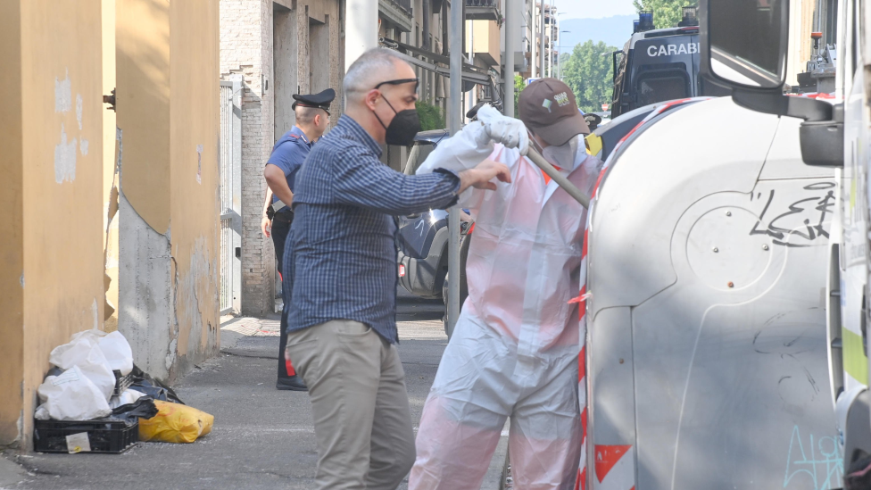 Policías inspeccionando un contenedor de basura