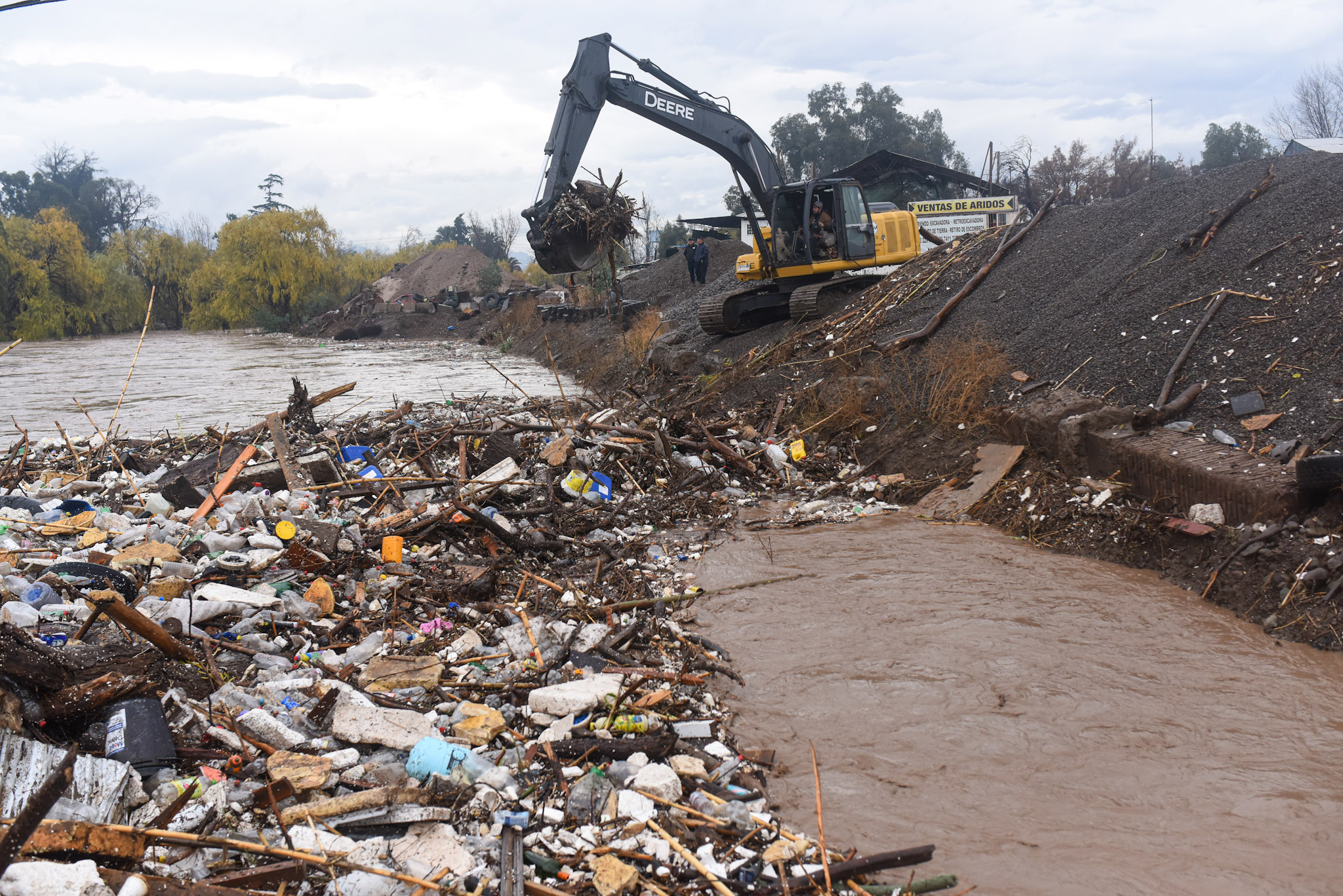 Puente mapocho siendo limpiado de basura.