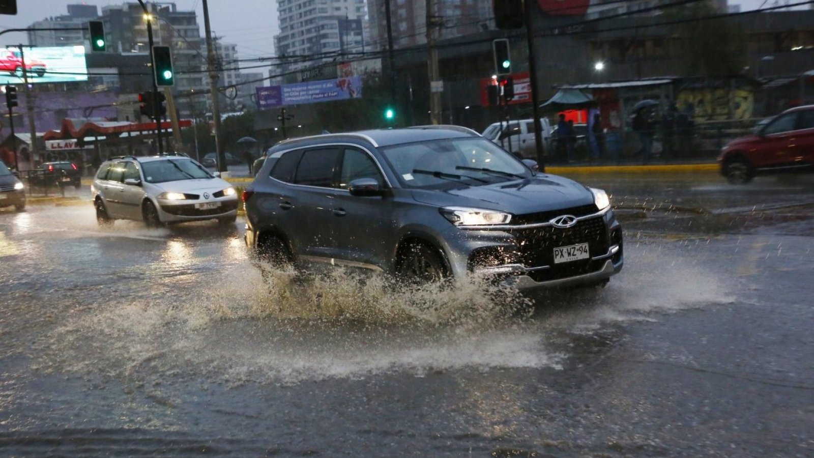 Auto pasando por calle anegada.